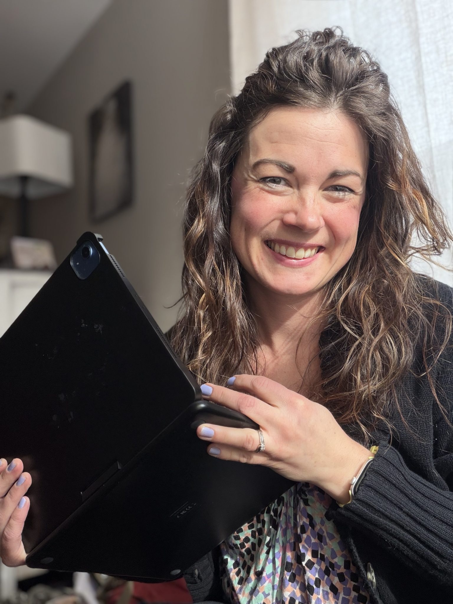 Jamie smiling while holding a laptop