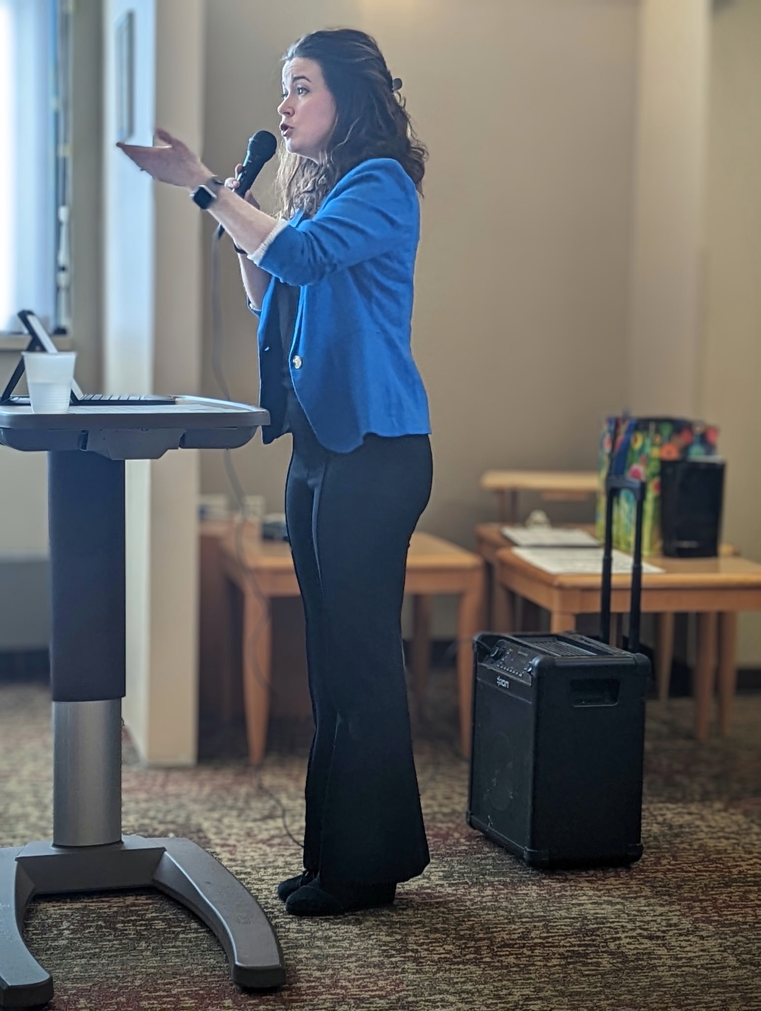 Jamie speaking into a microphone at an event